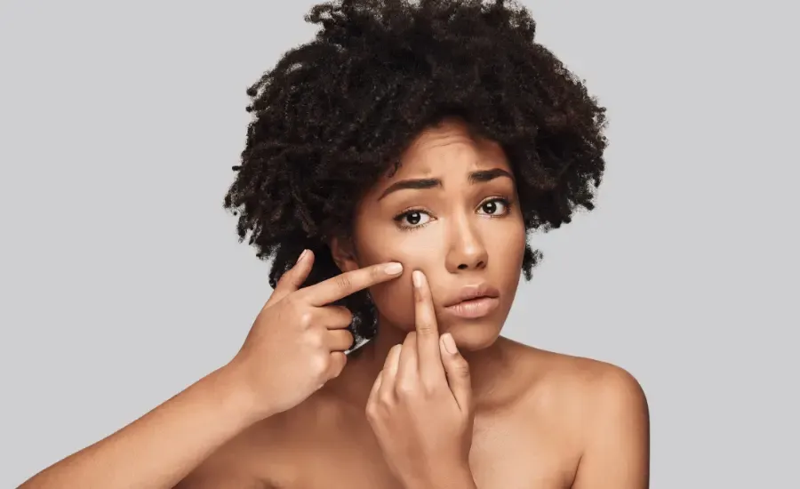 woman messing with a pimple