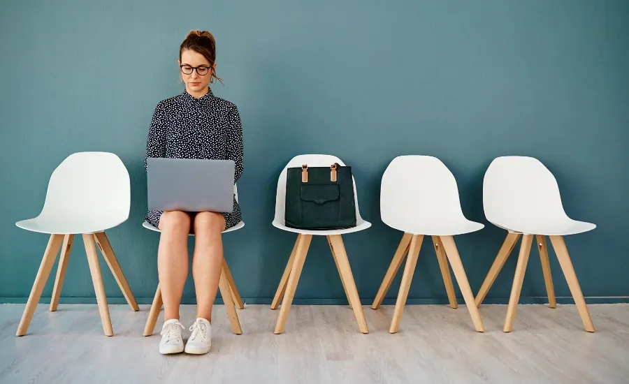 woman waiting in a chair while loud budgeting to save money