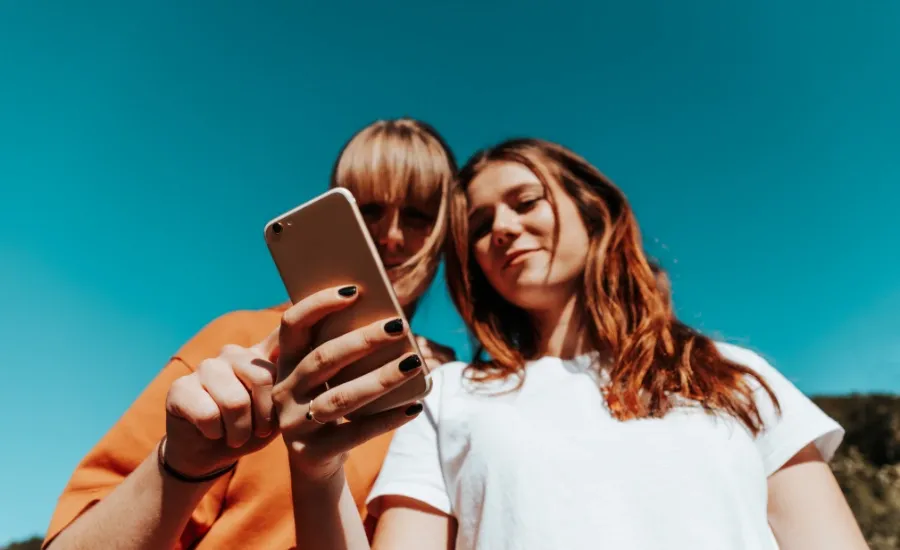 girls taking picture and posting on social media