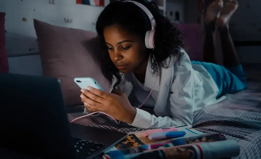 woman scrolling on phone in bed